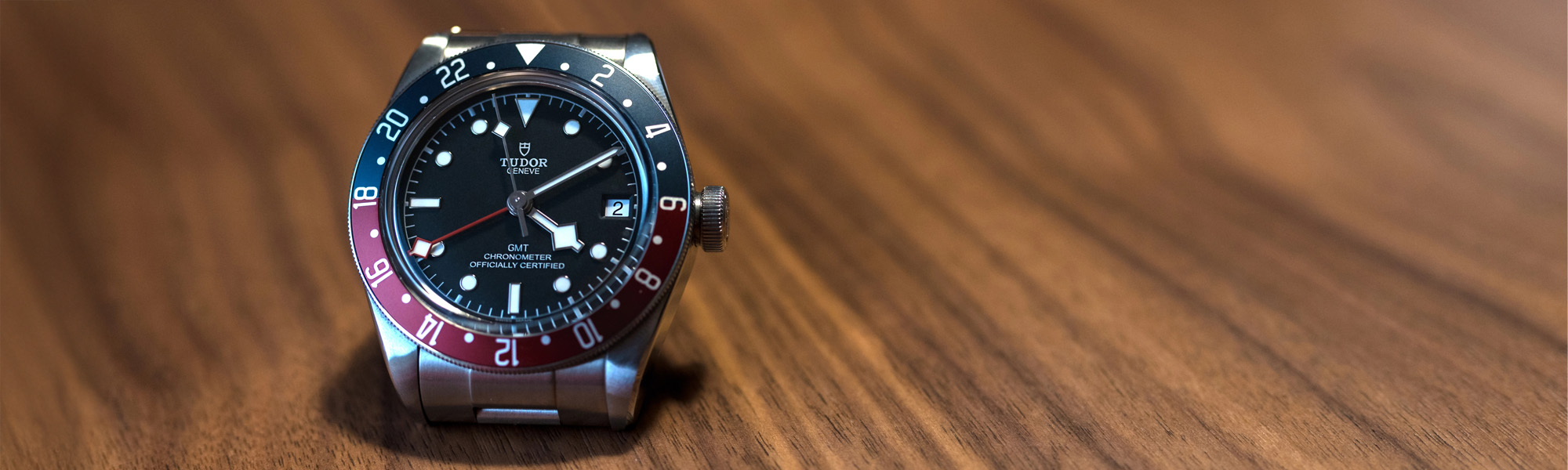 Tudor Black Bay GMT on a wooden surface banner